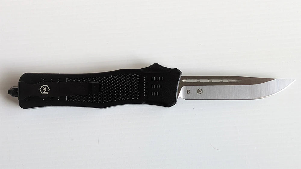 Large, lightweight Griffin knife. The blade comes standard in a D2 steel with a Drop Point blade with a non-serrated edge. The handle is a black ultralight anodized aluminum with a black switch. There is a belt clip for ease of carrying as well as glass break for safety.