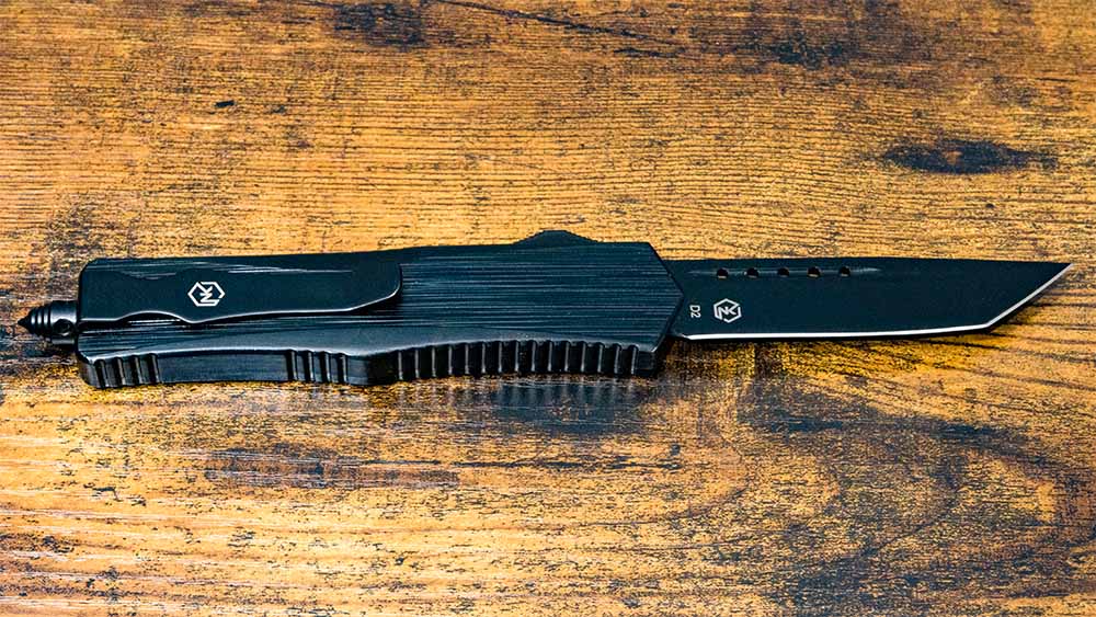 Black folding knife on a wooden surface