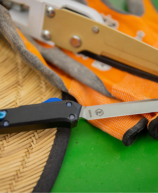Close-up of a knife with a black handle on an orange and green background